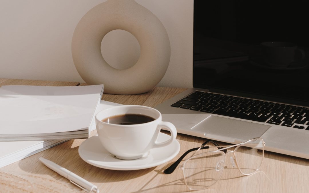 Desk with coffee and pair of large glasses with invisible rims.